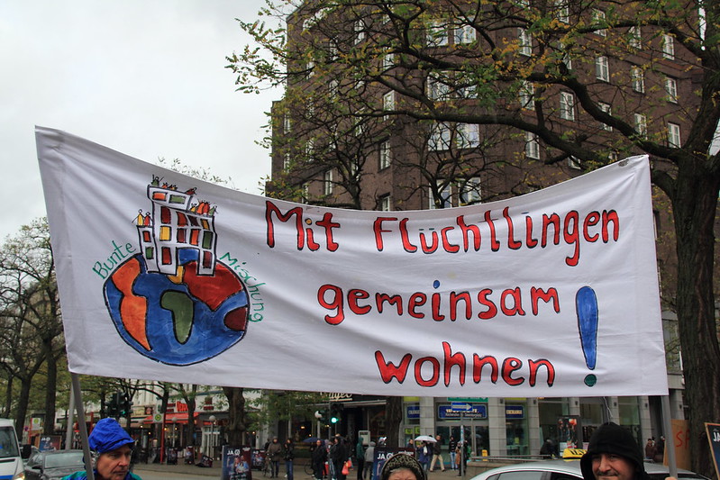 "Mieszkać razem z uchodźcami" - banner z demonstracji w Hamburgu 2014 (flickr)